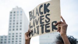 A protestor holds up a sign reading "Black Lives Matter" during a demonstration in Berlin, on July 10, 2016 with the motto "Black Lives Matter - No Justice = No Peace" as protest over the deaths of two black men at the hands of police last week. / AFP / dpa / Wolfram Kastl / Germany OUT        (Photo credit should read WOLFRAM KASTL/DPA/AFP via Getty Images)