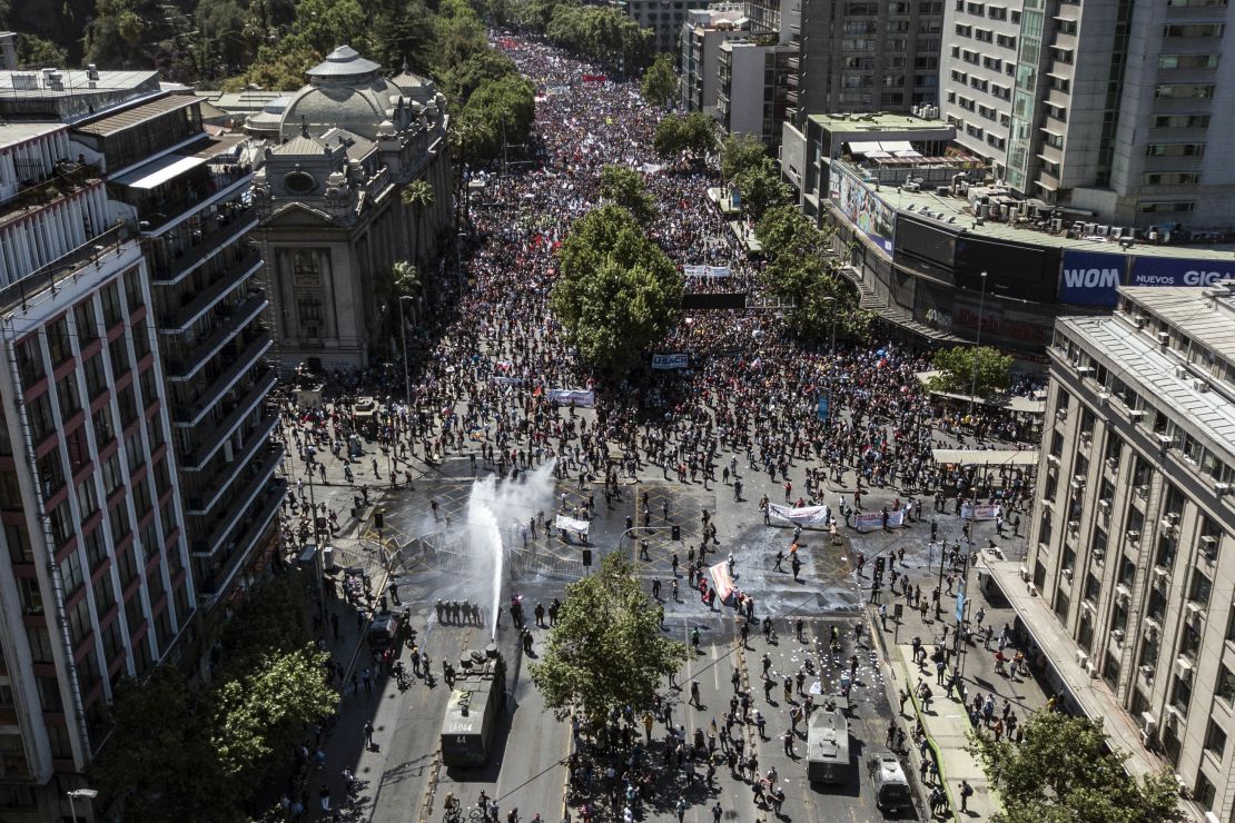 Aerial view showing riot police spraying water at demonstrators in Santiago on October 23, 2019.
