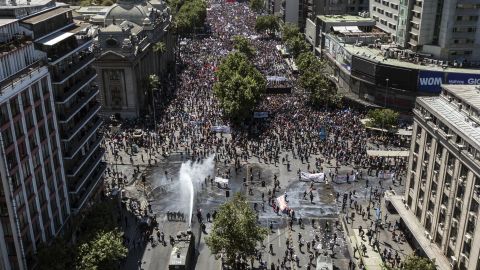 Aerial view showing riot police spraying water at demonstrators in Santiago on October 23, 2019.