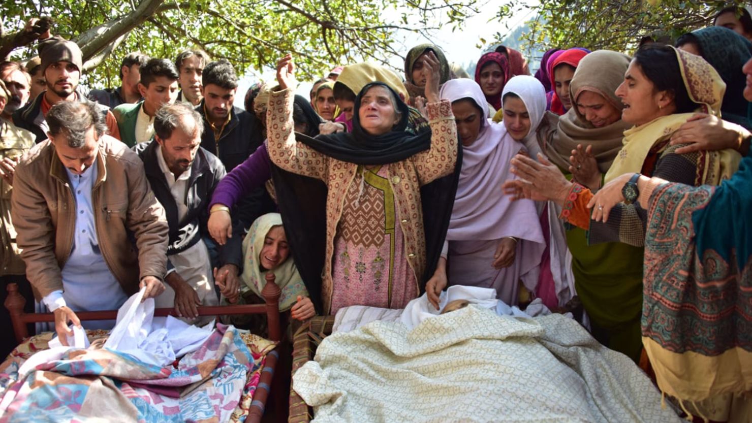 Relatives mourn next to bodies of victims in cross border shelling in Nousehri, a village in Neelum Valley on October 20, 2019.