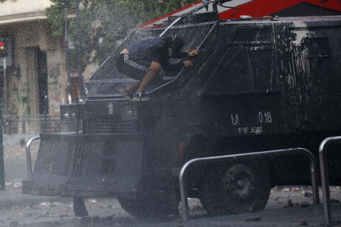 A demonstrator jumps in front of a police vehicle during the sixth day of protest against President Sebastian Pinera.