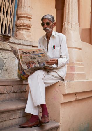 A dapper man in Jaipur, Rajasthan, reads a regional newspaper.