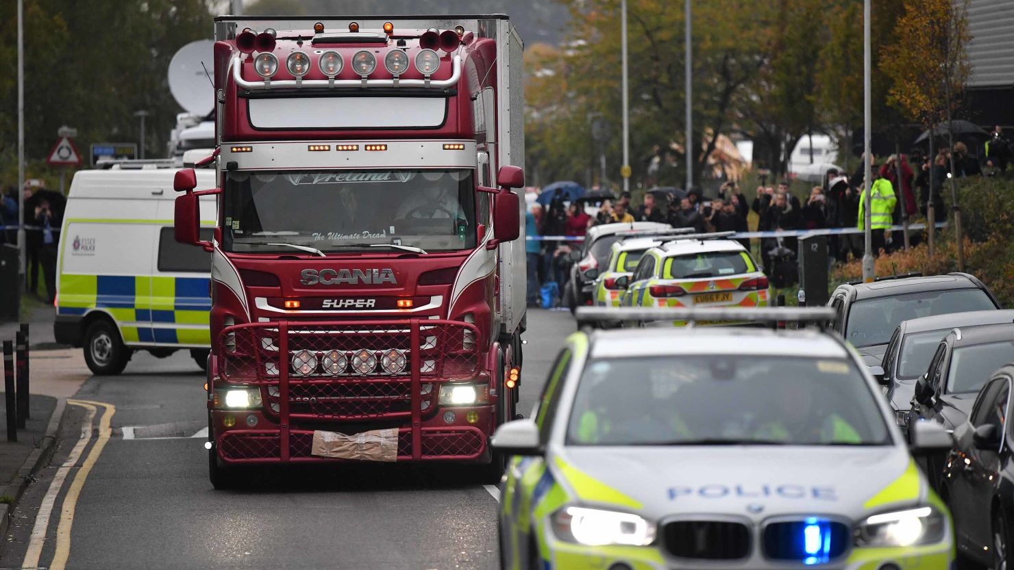 Police officers drive away the lorry in which 39 dead bodies were discovered.