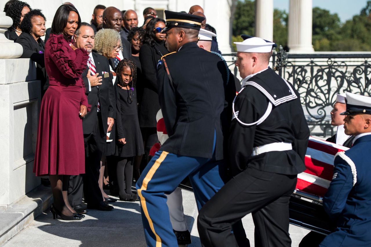 Cummings' wife watches as her husband's flag-draped casket is carried up the steps of the US Capitol on October 24.