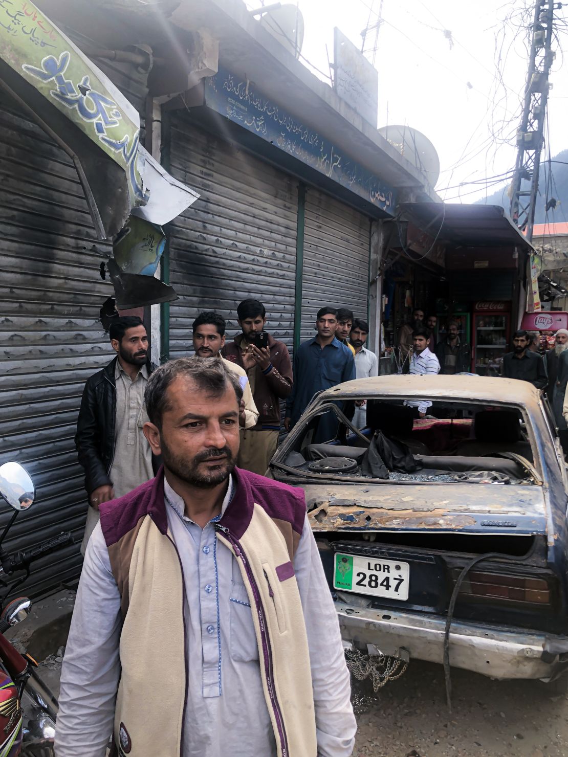 Scorched shutters, ripped store boards and a destroyed car on the main street of Jura in Pakistani-administered Kashmir on October 22, 2019.