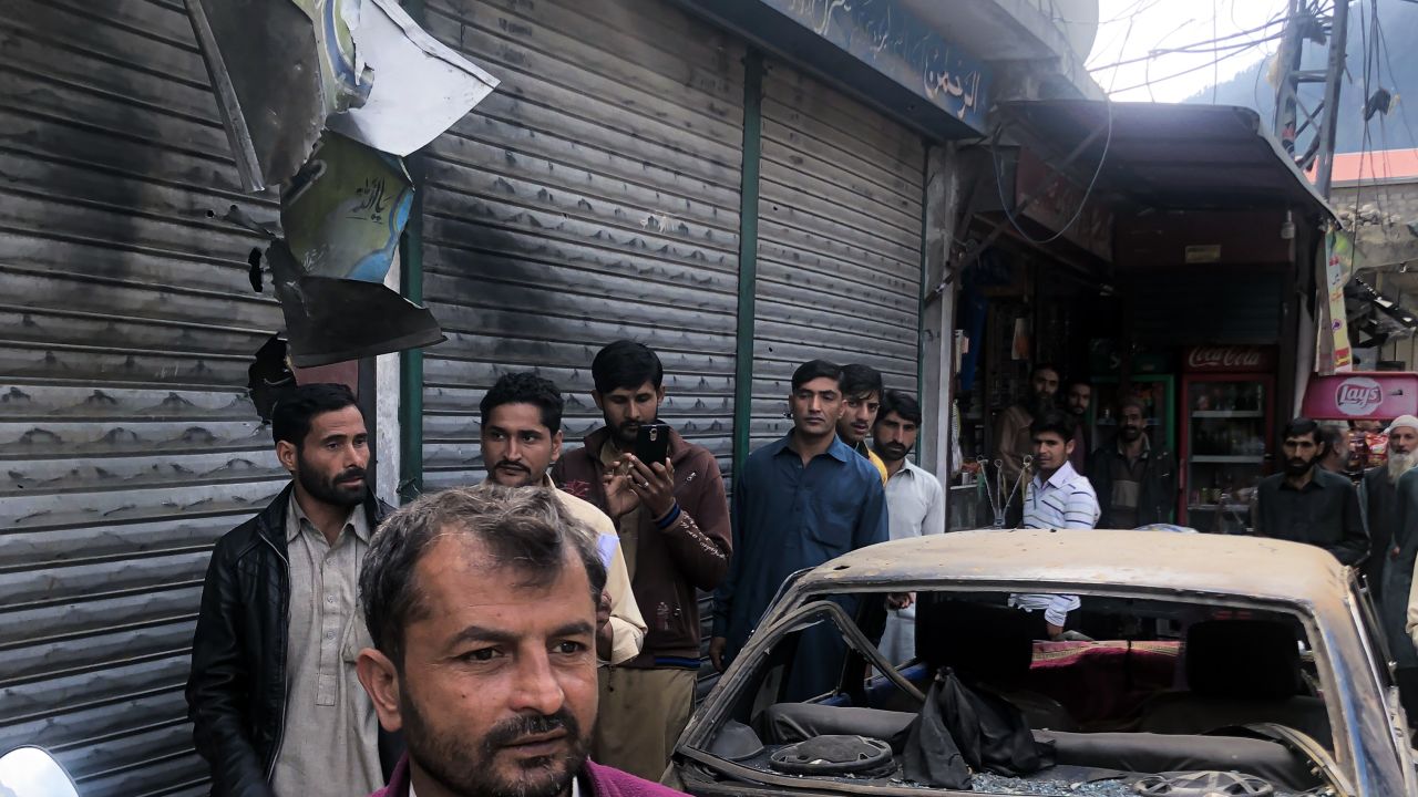 Scorched shutters, ripped store boards and a destroyed car on the main street of Jura in Pakistani-administered Kashmir on October 22, 2019.