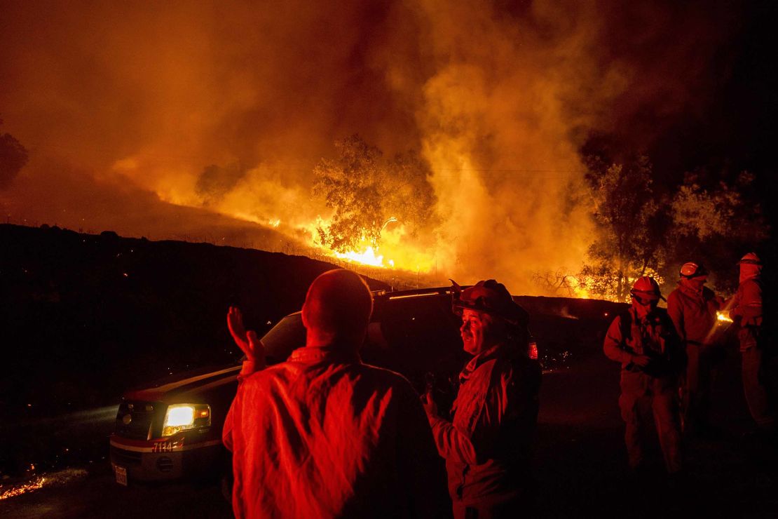 Firefighters confer while battling the Kincade Fire near Geyserville, California, on Thursday.