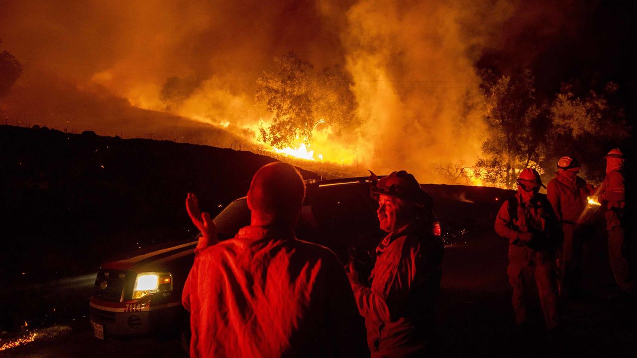 Firefighters confer while battling the Kincade Fire near Geyserville, California, on Thursday.