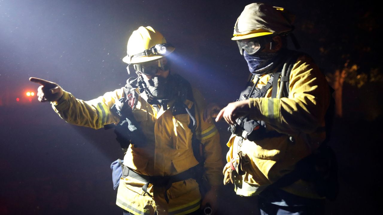 Two firefighters discuss a plan while battling the Kincade Fire in Geyserville on Thursday.