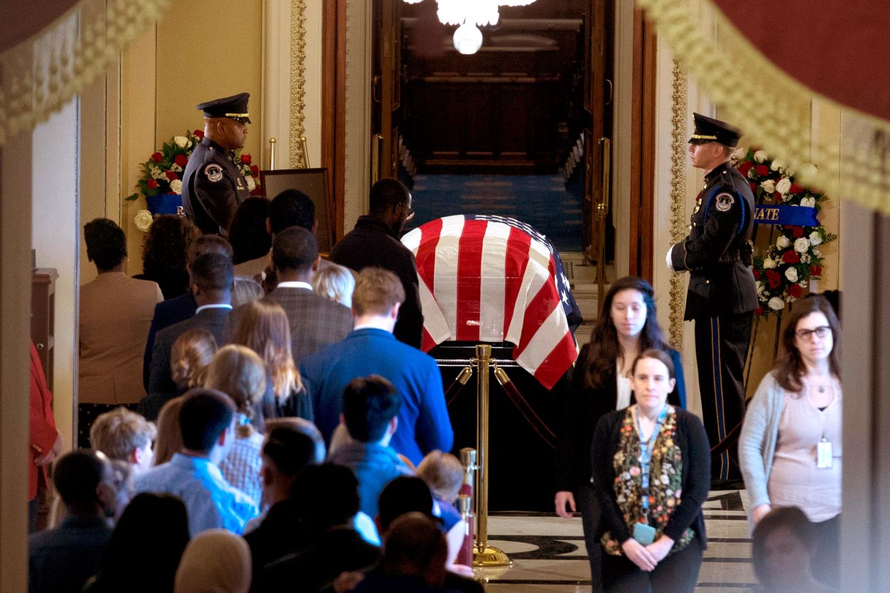 Visitors pay their respects as Cummings lies in state in front of the House Chamber door.
