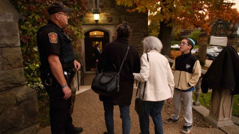 A police officer stands guard outside Temple Sinai before Friday evening Shabbat services in November 2018 in Pittsburgh. Temple Sinai, just a half mile from Tree of Life Synagogue, opened their doors to Pittsburgh-area Jews after the shooting