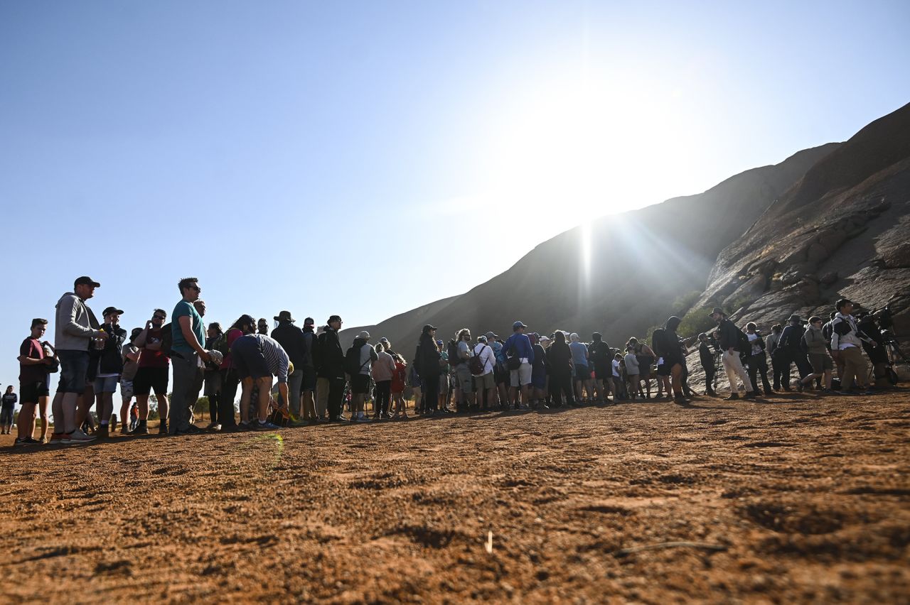 Tourists line up to climb Uluru on the eve of the October 26 climbing ban.