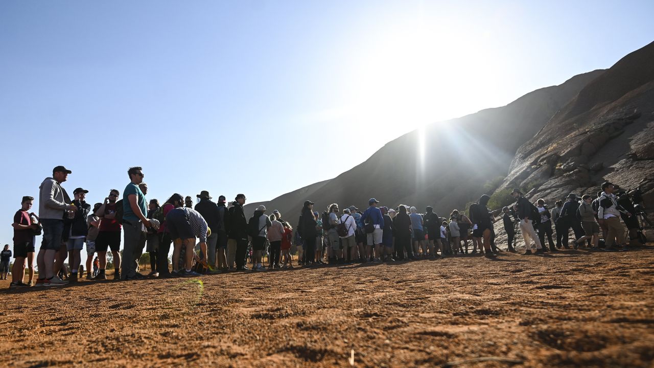 Tourists line up to climb Uluru on the eve of the October 26 climbing ban.