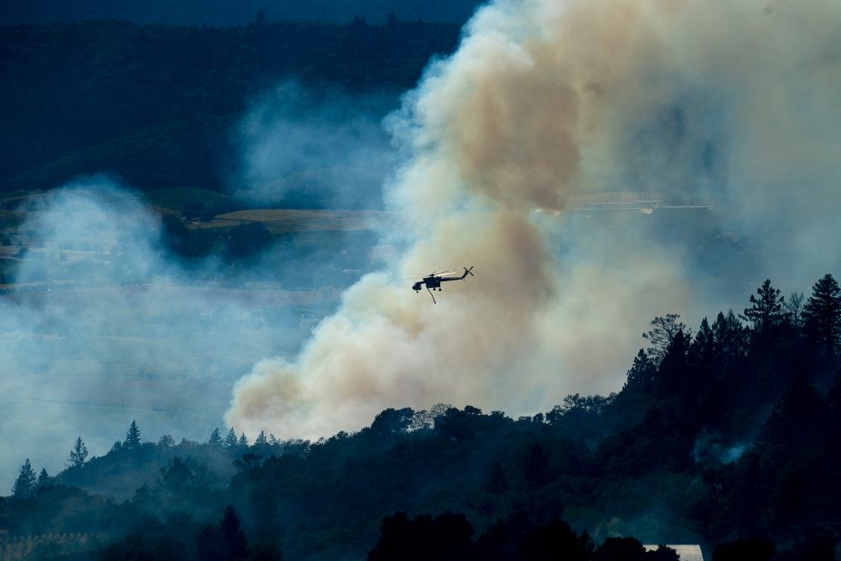 A helicopter passes a smoke plume on October 24. 