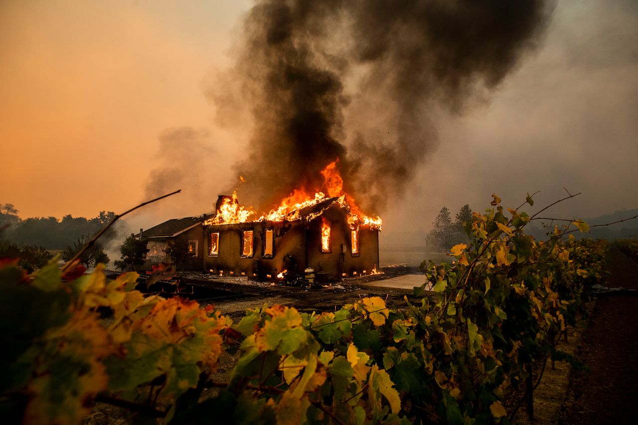 Vines surround a burning building as the Kincade Fire burns through the Jimtown community of unincorporated Sonoma County, California, on Thursday, October 24. 