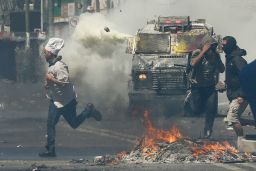 A man runs for cover as anti-government protesters clash with police in Valparaiso on Thursday.