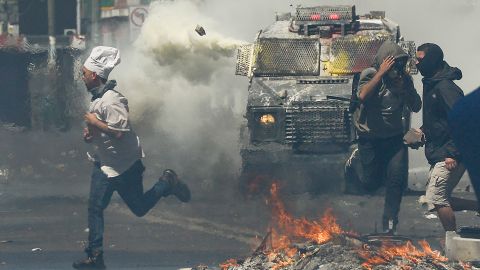 A man runs for cover as anti-government protesters clash with police in Valparaiso on Thursday.