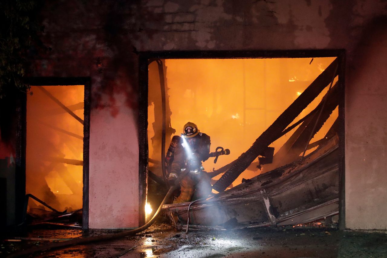 A firefighter works the scene of a burned-out home in Santa Clarita on October 24.