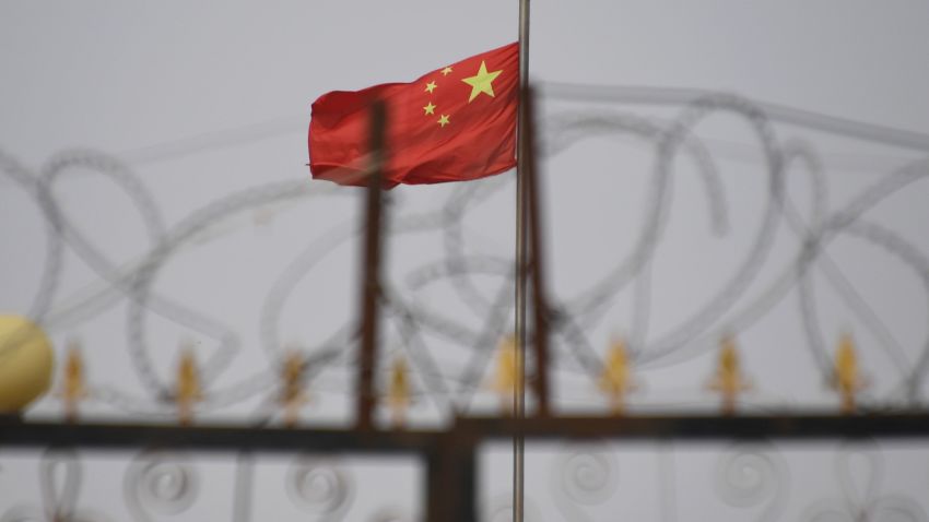 TOPSHOT - This photo taken on June 4, 2019 shows the Chinese flag behind razor wire at a housing compound in Yangisar, south of Kashgar, in China's western Xinjiang region. - A recurrence of the Urumqi riots which left nearly 200 people dead a decade ago is hard to imagine in today's Xinjiang, a Chinese region whose Uighur minority is straitjacketed by surveillance and mass detentions. A pervasive security apparatus has subdued the ethnic unrest that has long plagued the region. (Photo by GREG BAKER / AFP)        (Photo credit should read GREG BAKER/AFP/Getty Images)