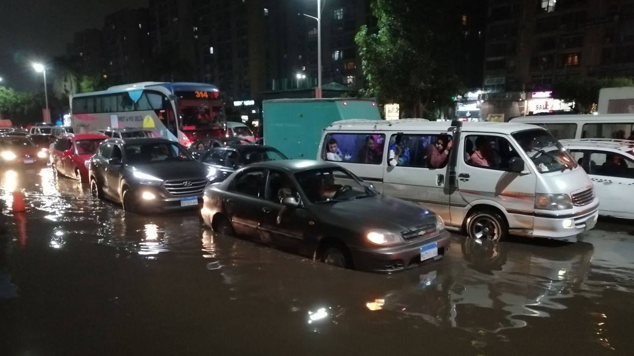 Cars drive on a flooded street following rainfall that led to traffic jam in the Heliopolis district in the Egyptian capital Cairo on October 22, 2019.