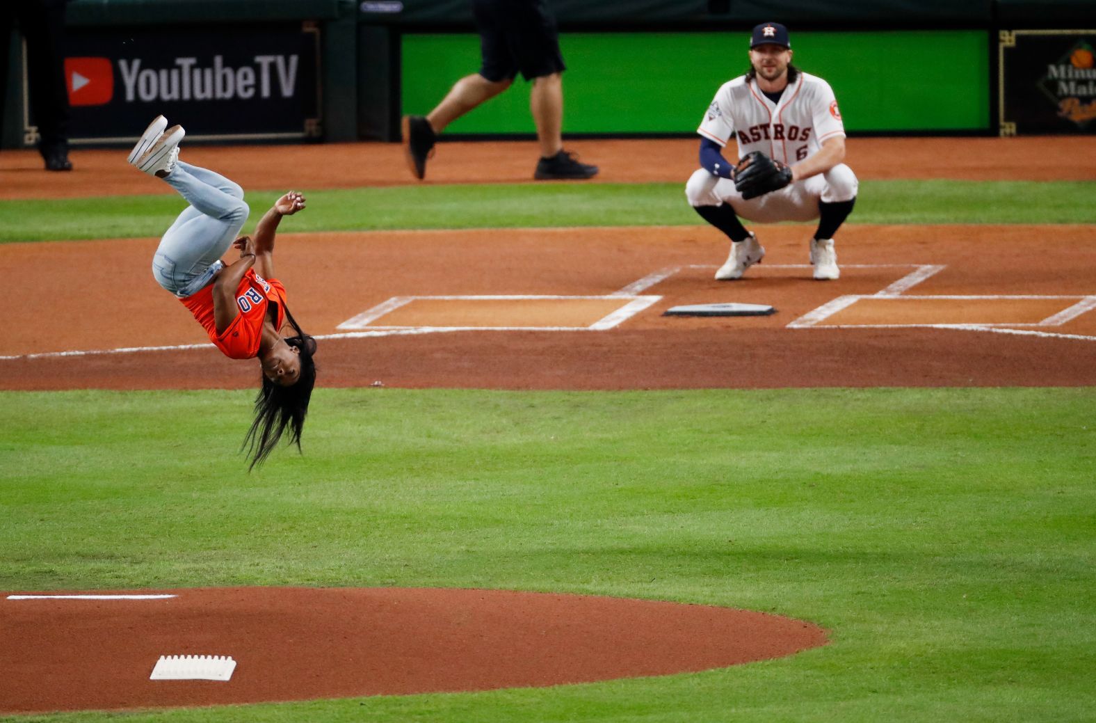 World champion gymnast Simone Biles performs a flip before throwing out the first pitch for Game 2.