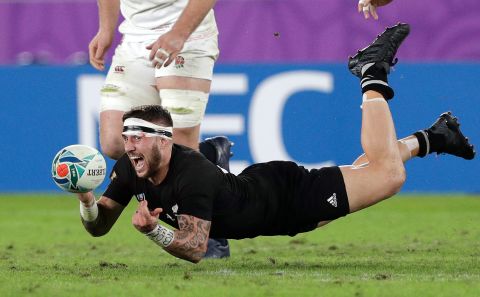 New Zealand's TJ Perenara passes the ball before he hits the ground during the semifinal against England.