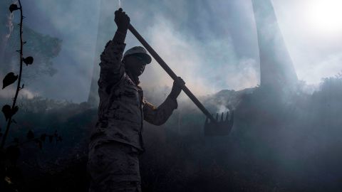 A Mexican soldier works to contain a brush fire on the outskirts of Tijuana in Baja California 