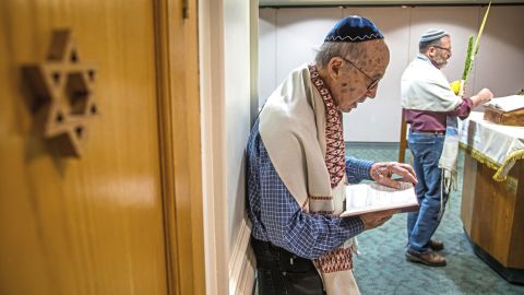 Joe Charny reads during a morning minyan prayer service at Congregation Beth Shalom.