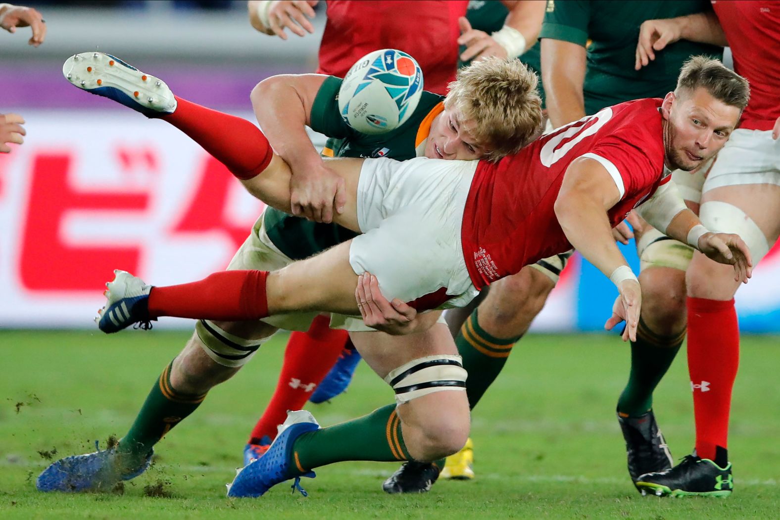 Wales' Dan Biggar passes the ball as he is tackled by Du Toit during the Rugby World Cup semifinal.