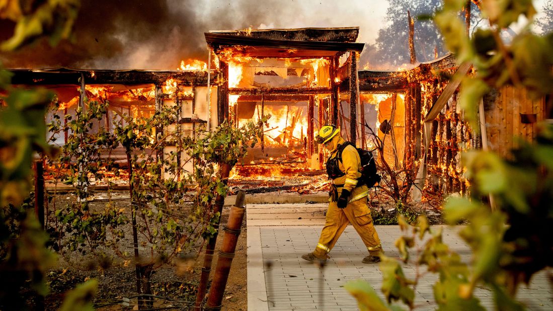 A firefighter passes a burning home as the Kincade Fire rages in Healdsburg on October 27.