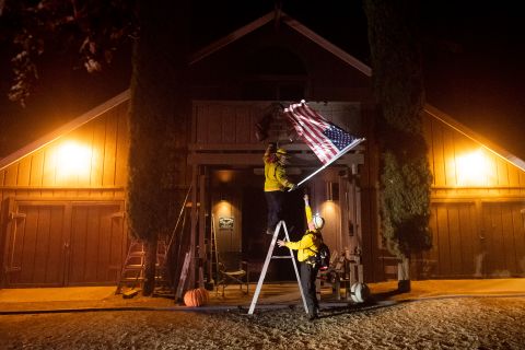 Firefighters from the Dry Creek Rancheria remove an American flag in Healdsburg.