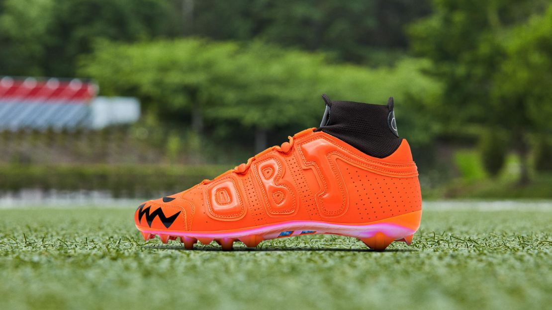 The neon orange cleat features Halloween-inspired designs.