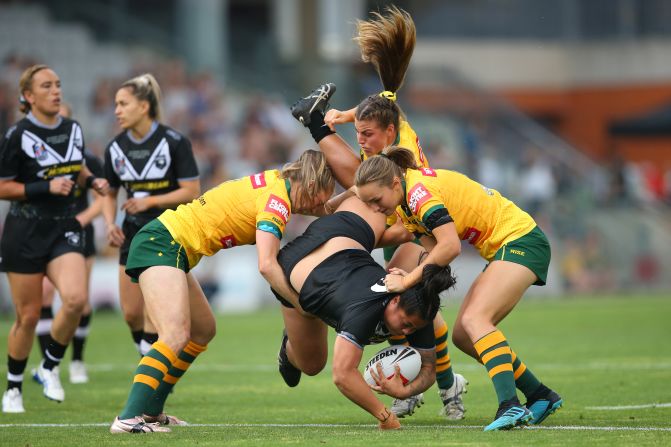 New Zealand's Annetta Nuuausala is tackled by Australian players during an International Rugby League match in Wollongong, Australia, on Friday, October 25.