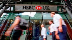 Pedestrians walk past a HSBC UK bank branch in central London on July 31, 2018. - HSBC will publish their half-year results on August 6. (Photo by Tolga Akmen / AFP) 