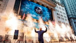 Sir Richard Branson, founder of Virgin Galactic, poses for a photo outside the New York Stock Exchange as fireworks are exploded before his company's IPO, Monday, Oct. 28, 2019. (AP Photo/Richard Drew)