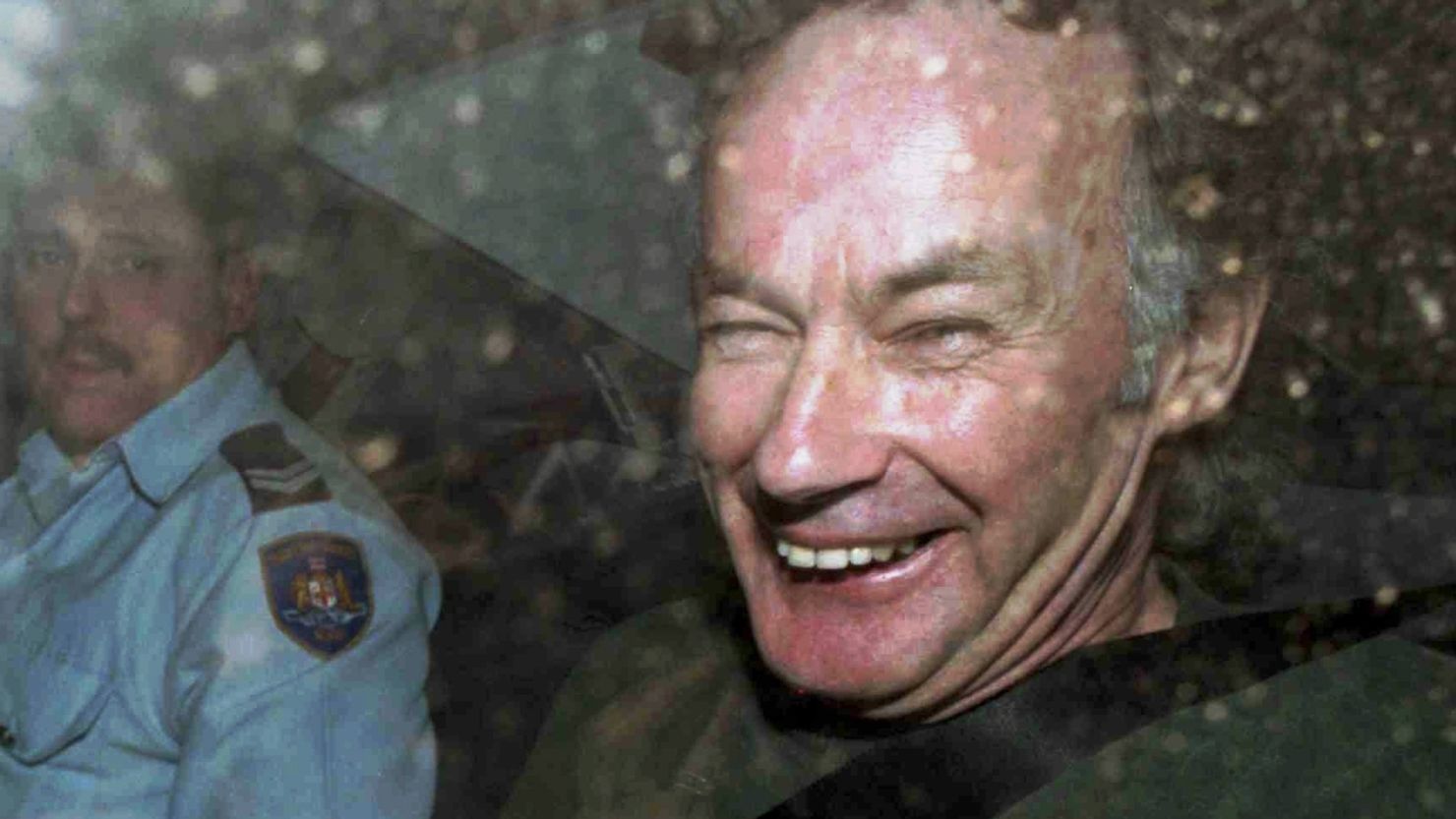 Ivan Milat smiles in a police car after attending a court in Sydney, Australia, on November 4, 1997.