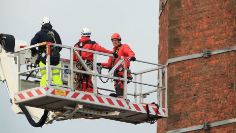 Members of Lancashire Fire and Rescue Service use a hydraulic platform at Dixon's Chimney in Carlisle, England, where a man was hanging upside down from the top of the 270-foot chimney.