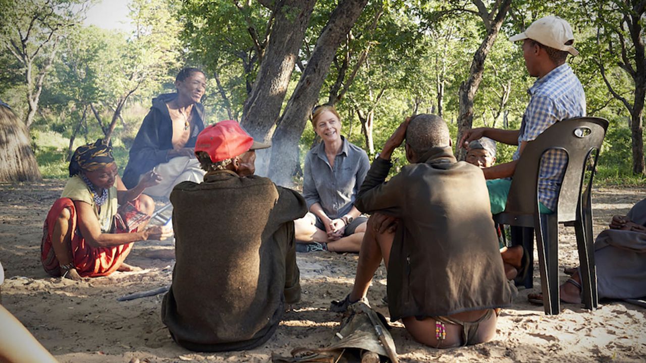 Hayes sits with Juǀ'hoansi hunters Nǂamce Sao, ǀkun Nǂamce and ǀkun ǀkunta (left to right).