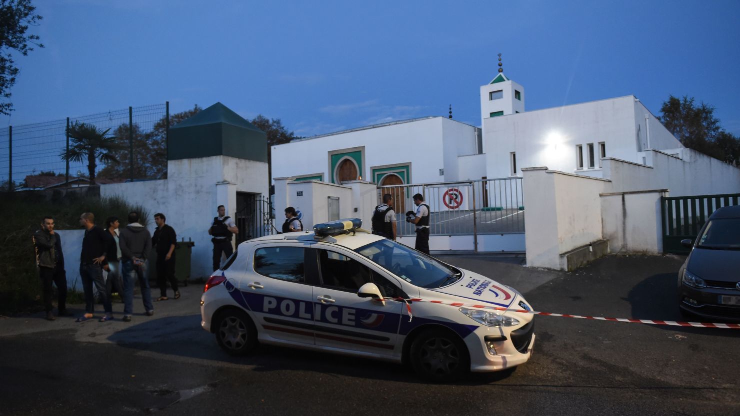 Police officers stand in front of the Mosque of Bayonne after two people were injured in a shooting.