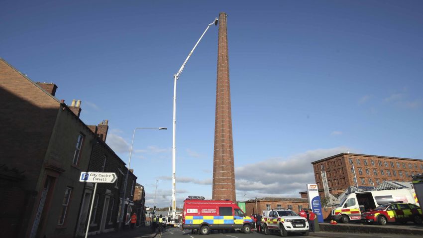 Chimney rescue. A hydraulic platform is raised at Dixon's Chimney in Carlisle, Cumbria, where a man, whose condition is currently unknown, continues to hang upside down from the top of the chimney 270ft up. Picture date: Monday October 28, 2019. Local reports said shouts and wailing could be heard coming from the chimney in the early hours of this morning before police arrived on the scene. See PA story POLICE Chimney. Photo credit should read: Danny Lawson/PA Wire URN:47938205 (Press Association via AP Images)