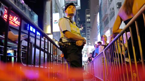 A police officer stands guard as people celebrate Halloween in Lan Kwai Fong in 2017.