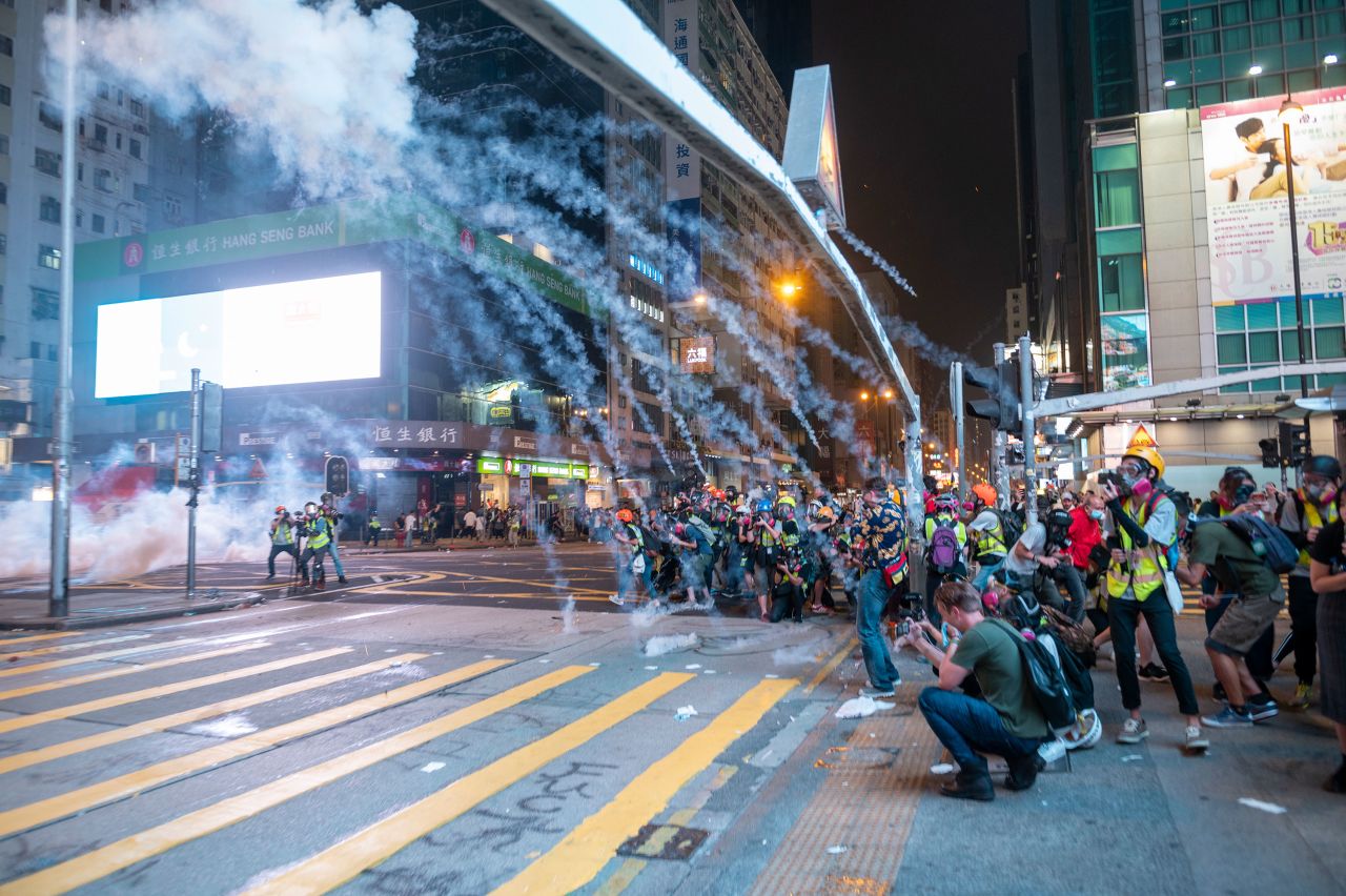 Tear gas smoke is seen exploding over reporters during an anti-government protest in Mong Kok district in Hong Kong on October 27.