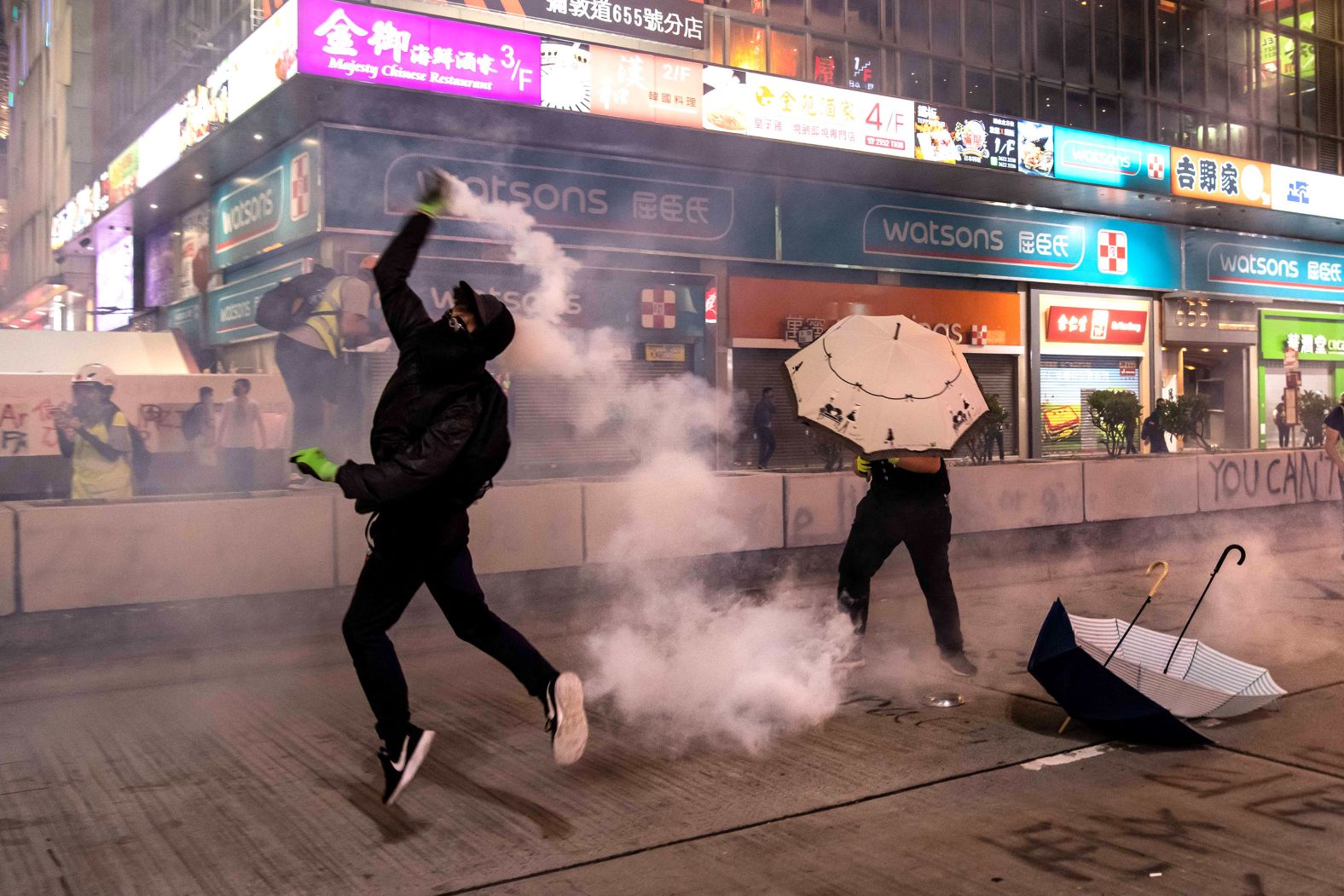 A protester throws a tear gas canister on October 27 in Hong Kong.