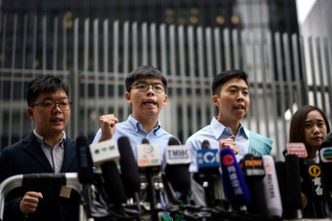 Pro-democracy activist Joshua Wong (second from left) and Kelvin Lam (second from right) shout slogans as they meet the media outside the Legislative Council (LegCo) in Hong Kong on October 29, 2019, after Wong was barred from standing in an upcoming local election.