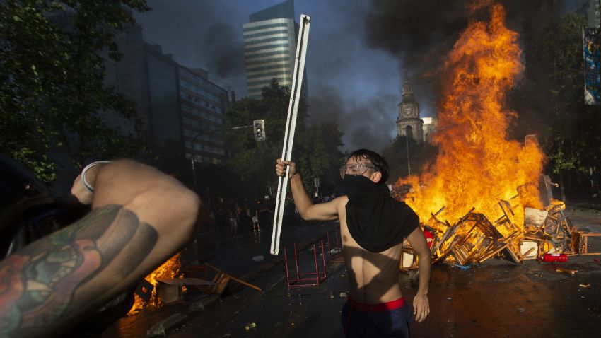 Demonstrators stand by a fire barricade during clashes with riot police outside La Moneda presidential palace, in Santiago, on October 28, 2019. - Chilean President Sebastian Pinera unveiled a major cabinet reshuffle on Monday as he battles to find a response to more than a week of street protests that have left at least 20 people dead. (Photo by CLAUDIO REYES / AFP) (Photo by CLAUDIO REYES/AFP via Getty Images)