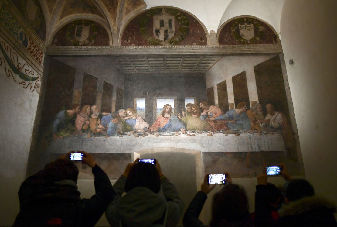 Visitors take photos of "The Last Supper" ("Il Cenacolo" or "L'Ultima Cena"), Italian artist Leonardo da Vinci's late 15th-century mural painting housed by the refectory of the Convent of Santa Maria delle Grazie in Milan, on May 8, 2019.