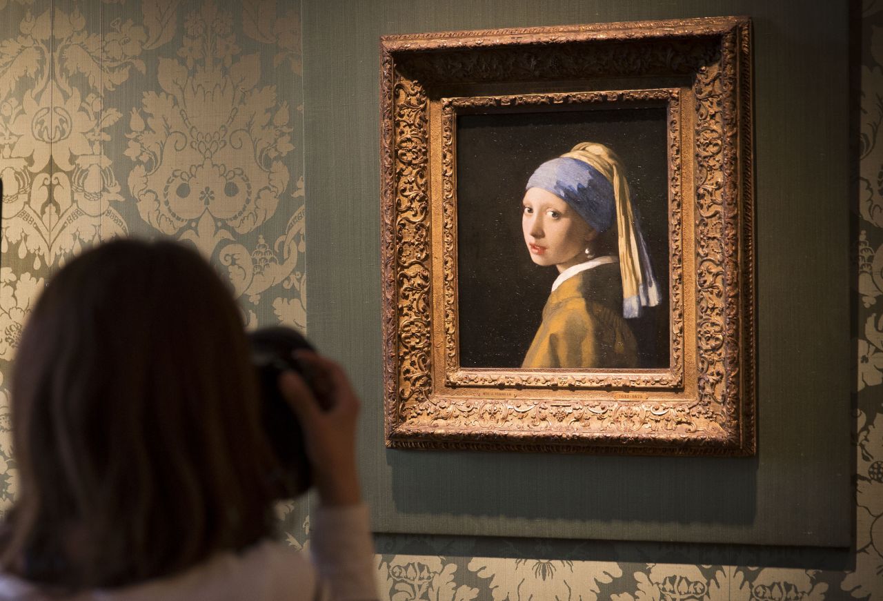 A journalist takes a photo of Johannes Vermeer's "Girl with a Pearl Earring" at the Mauritshuis Museum in The Hague, Netherlands.
