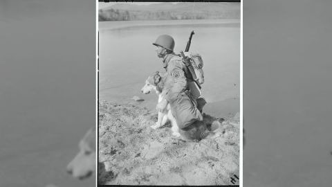 1940: Sgt. Stanley Novak rests at a lakeside with "Mukluk" during the training routine on Lake Chiquora.