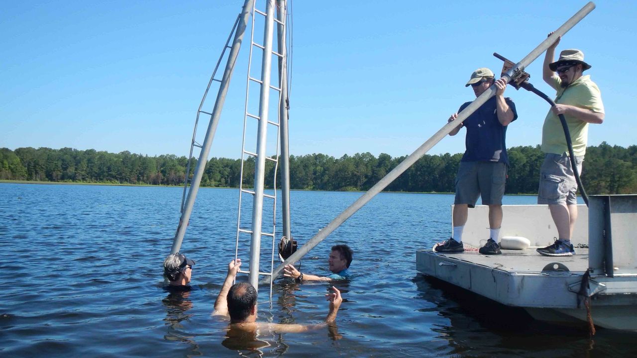 University of South Carolina archaelogist Christopher Moore (second from right) and colleagues collect core samples from White Pond near Elgin, South Carolina, to look for evidence of an impact from an asteroid or comet that may have caused the extinction of large ice-age animals such as sabre-tooth cats and giant sloths and mastodons.