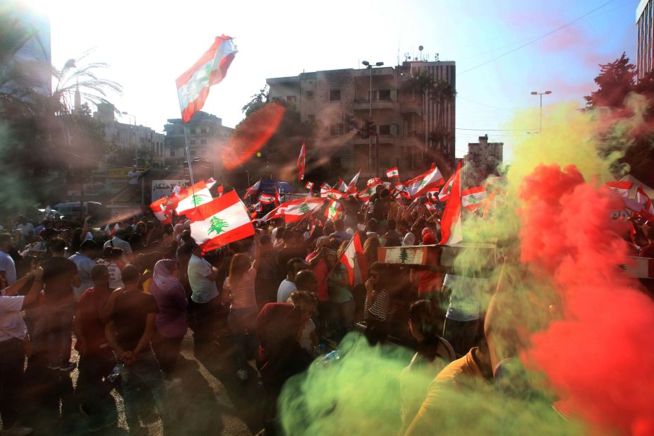 Demonstrators wave flags as they gather in the southern city of Sidon on October 19.